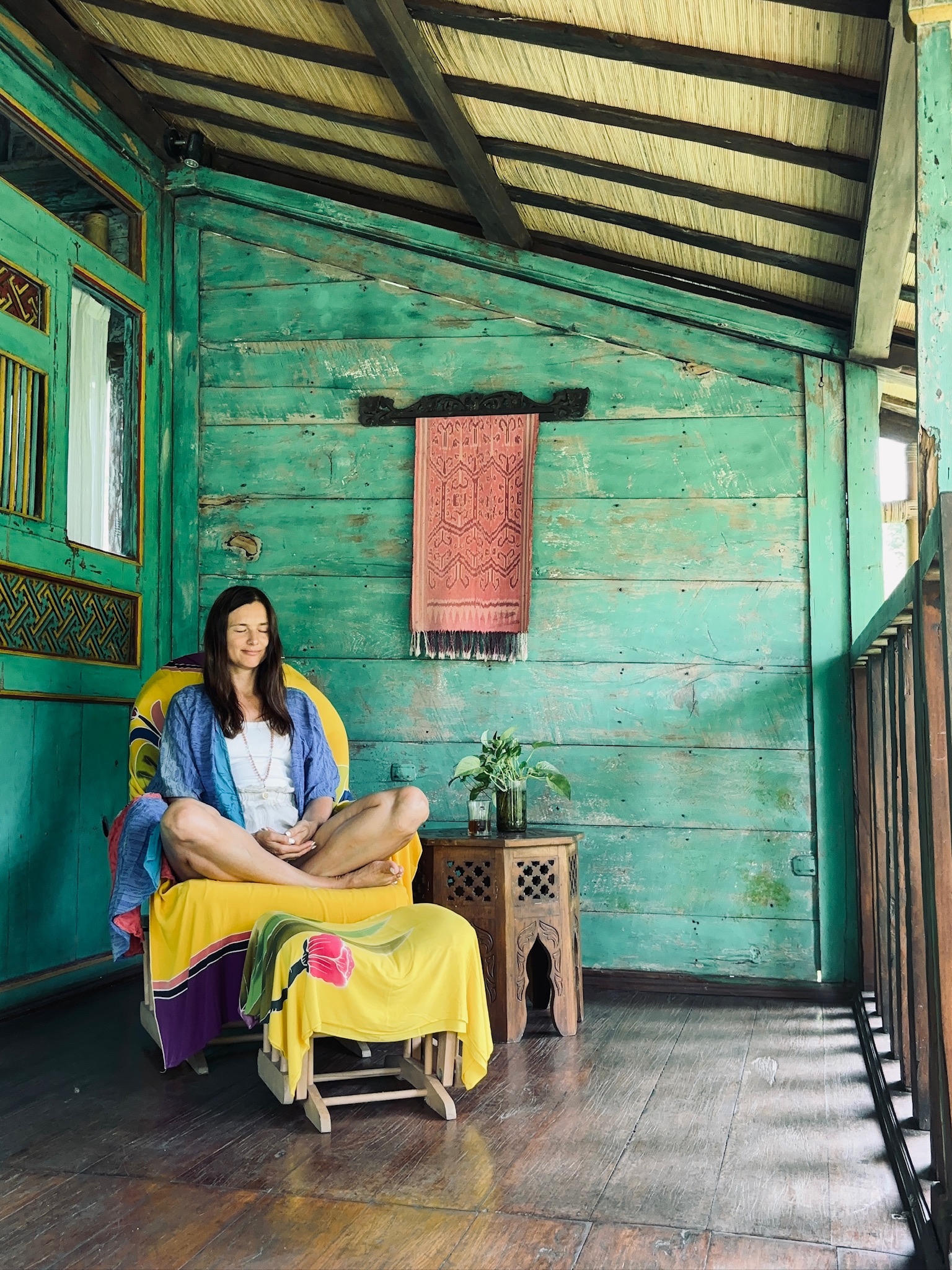 Natalia meditating in a wooden retreat space in Bali