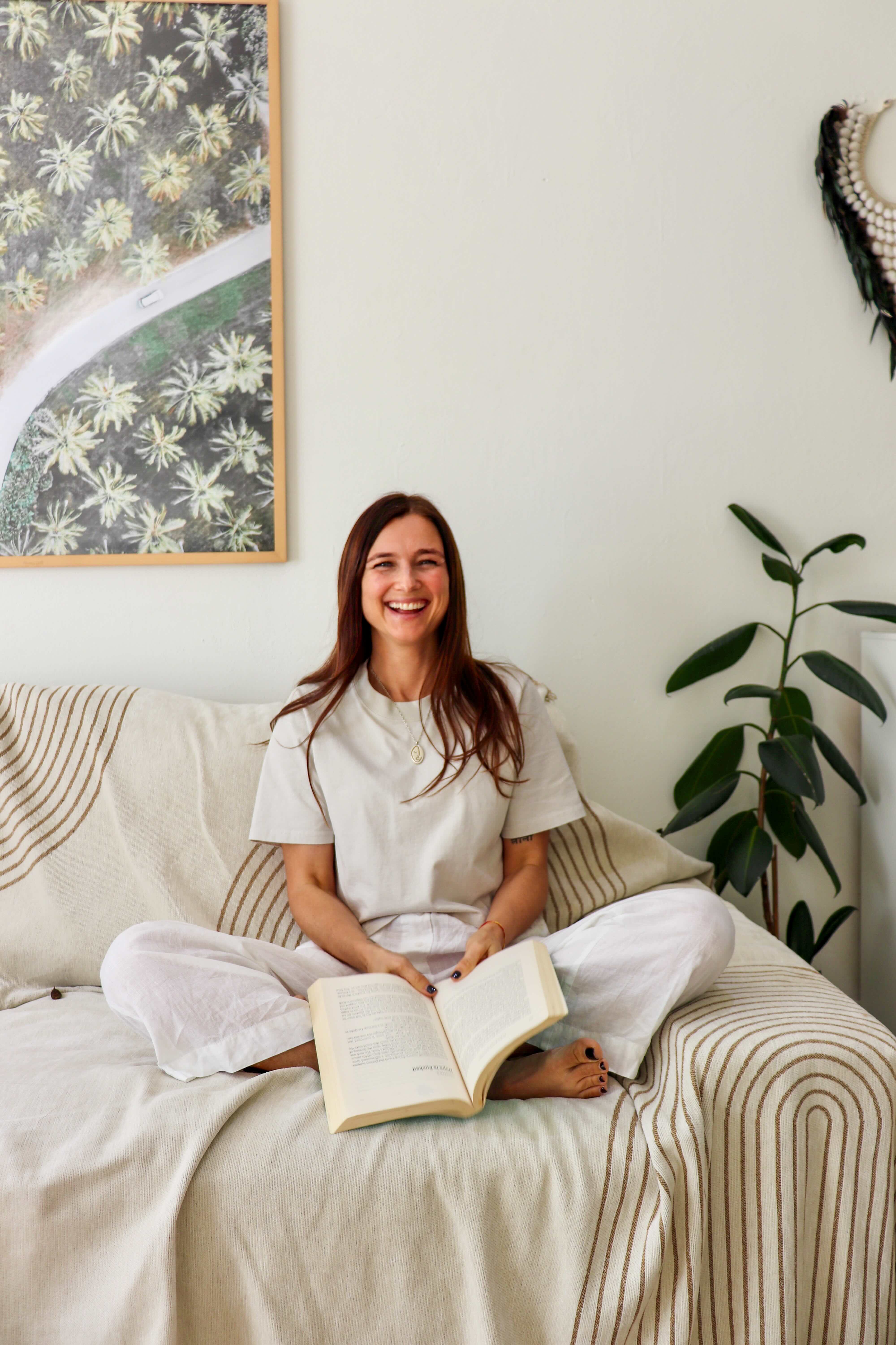 Natalia sitting on a sofa reading a book at home in Sydney