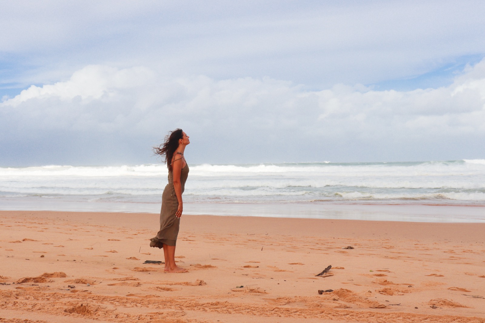 Natalia Paklina standing on a beach, face lifted to the sky
